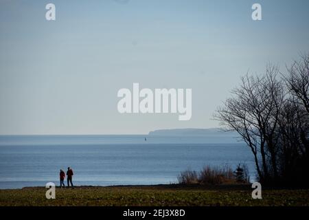 21. Februar 2021, Schleswig-Holstein, Lübeck: Tagesausflügler machen bei frühlingshaften Temperaturen einen Spaziergang entlang der Küste am Brodtener Steilufer in der Lübecker Bucht. Foto: Gregor Fischer/dpa Stockfoto