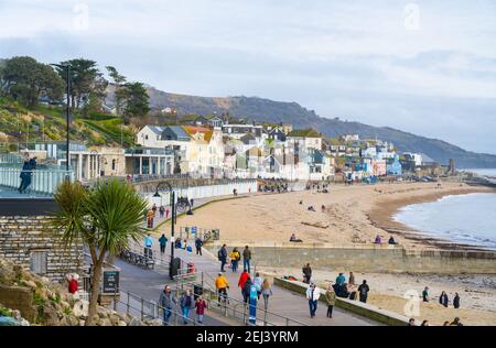 Lyme Regis, Dorset, Großbritannien. Februar 2021, 21st. UK Wetter: Die Menschen genießen einen warmen und sonnigen Sonntagnachmittag am Strand am Badeort Lyme Regis, da die jüngsten nassen und düsteren Wetter klar bringt wärmer, sonnigere Bedingungen nächste Woche. Kredit: Celia McMahon/Alamy Live Nachrichten Stockfoto