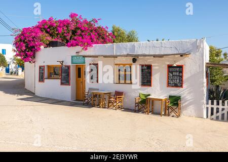 Chora, Insel Folegandros, Griechenland - 25. September 2020: Traditionelle griechische weiße Architektur im Zentrum von Chora. Rosa Bugenwilla auf dem Dach. Stockfoto