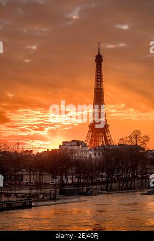 Paris, Frankreich - 12. Februar 2021: Stadtbild von Paris im Winter. Schiffe und Brigde über die seine mit Eiffelturm im Hintergrund und dramatisch bewölkt Stockfoto
