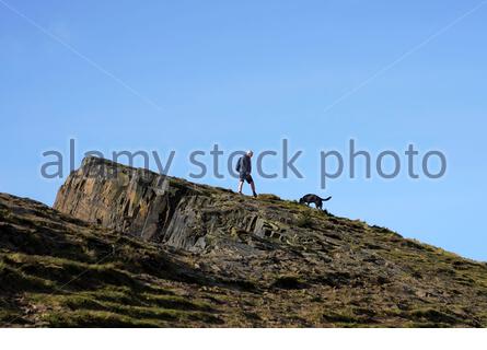 Edinburgh, Schottland, Großbritannien. Februar 2021, 21st. Menschen genießen die Sonne und im Freien im Holyrood Park. Wandern mit dem Hund auf Salisbury Crags. Kredit: Craig Brown/Alamy Live Nachrichten Stockfoto
