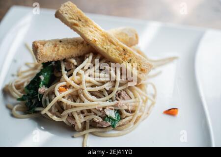 Ein Spaghettigericht mit Brot auf einem weißen Teller Die Tabelle Stockfoto