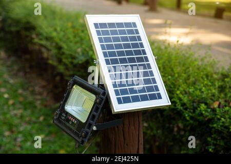 Ökologische elektrische Energie aus Solarpanel im Feld. Solarzellenlampe auf grünem Feld Hintergrund. Alternative Energie aus der Sonne. Stockfoto
