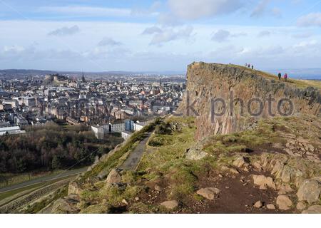 Edinburgh, Schottland, Großbritannien. Februar 2021, 21st. Menschen genießen die Sonne und im Freien im Holyrood Park. Von den Salisbury Crags hat man einen Blick auf das Edinburgh Castle und die Dächer des Stadtzentrums. Kredit: Craig Brown/Alamy Live Nachrichten Stockfoto