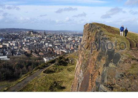 Edinburgh, Schottland, Großbritannien. Februar 2021, 21st. Menschen genießen die Sonne und im Freien im Holyrood Park. Von den Salisbury Crags hat man einen Blick auf das Edinburgh Castle und die Dächer des Stadtzentrums. Kredit: Craig Brown/Alamy Live Nachrichten Stockfoto