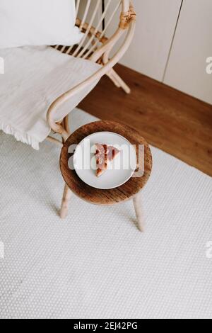 Ein Stück hausgemachten Apfelkuchen auf einem Holz Hocker im Wohnzimmer Stockfoto