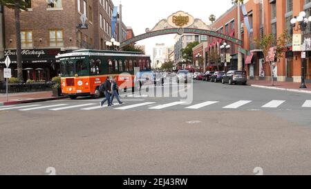 SAN DIEGO, CALIFORNIA USA - 30 JAN 2020: Gaslamp Quarter Historic Eingang Bogen Zeichen auf 5th Avenue. Orange kultige Retro-Trolley, Hop-on-Hop-off-Bus und Stockfoto
