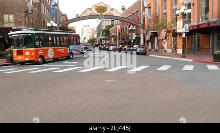 SAN DIEGO, CALIFORNIA USA - 30 JAN 2020: Gaslamp Quarter Historic Eingang Bogen Zeichen auf 5th Avenue. Orange kultige Retro-Trolley, Hop-on-Hop-off-Bus und Stockfoto