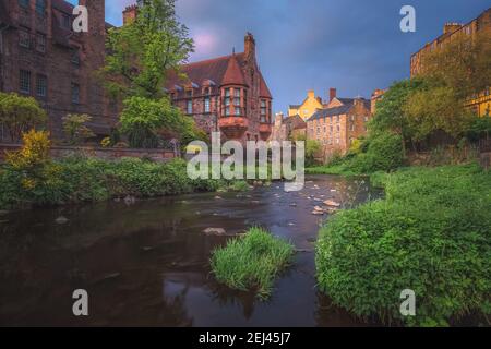 Ein stimmungsvoller Himmel bei Sonnenuntergang oder Sonnenaufgang im historischen Dean Village aus dem 19th. Jahrhundert und Water of Leith in Edinburgh, Schottland. Stockfoto