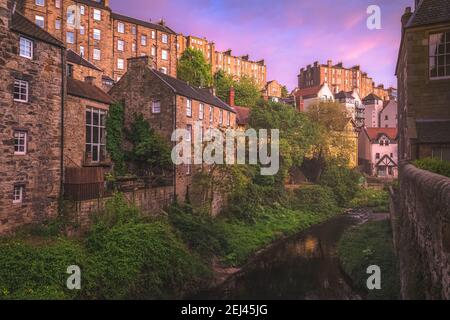 Ein lebendiger farbenfroher Sonnenuntergang oder Sonnenaufgang Blick auf die historische Altstadt Dean Village und Water of Leith in Edinburgh, Schottland im Frühling. Stockfoto