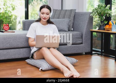 Junge Studentin, die online Unterricht ansieht und von zu Hause aus studiert. Sie benutzt Laptop und lernt online. Fernunterricht Online-Bildung. Stockfoto