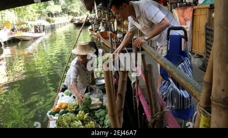 BANGKOK, THAILAND - 13. JULI 2019: Lat Mayom schwimmenden Markt. Traditioneller klassischer khlong-Flusskanal, einheimische Bauernfrauen, Langschwanz-Boote mit Früchten Stockfoto