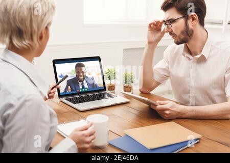 Telekonferenz-Meeting. Schwarzer Geschäftsmann mit Videoanruf mit seinem Business-Team online Stockfoto