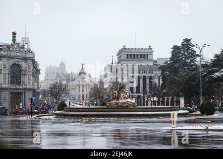 MADRID - 8. JANUAR 2021: Cibeles Brunnen im Zentrum von Madrid unter starkem Schnee während eines Schneesturms im Winter, mit Alcala und Gran Via Straßen in der b Stockfoto