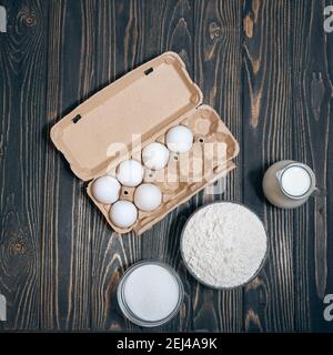 Backkuchenzutaten: Mehl, Zucker, Eier auf Holztisch, flaches Lay Stockfoto