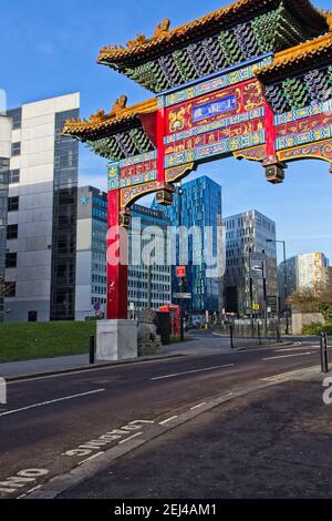 Ein sehr farbenprächtiger Eingang markiert den Eingang in die Chinatown-Gegend von Newcastle upon Tyne mit sehr moderner Architektur im Hintergrund. Stockfoto