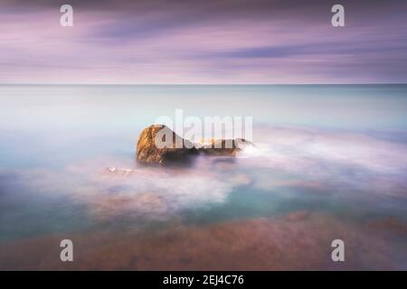 Felsen, weiches Meer und Wolken am Himmel, schöne Landschaft in Langzeitbelichtung Fotografie. Castiglioncello, Toskana, Italien. Stockfoto