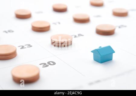 Hypothek Immobilien Miete Zahlungen in Raten Darlehen Haus Modell. Familienbudget Haus Hypothek Zahlung fällig am Ende des Monats Kalender mit Münzen Stapel Stockfoto