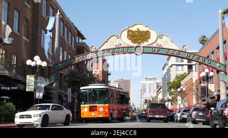 SAN DIEGO, CALIFORNIA USA - 13 FEB 2020: Gaslamp Quarter historisches Eingangsbogenschild auf 5th Avenue. Orange kultige Retro-Trolley, Hop-on-Hop-off-Bus und Stockfoto
