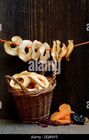 Getrocknete Früchte, Apfelringe in Körben, Apfelringe an Schnur, Aprikosen, Pflaumen und Preiselbeeren Stockfoto