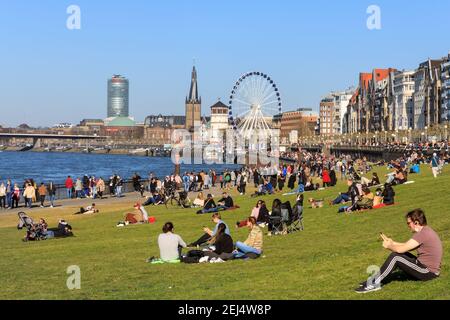 Düsseldorf, NRW, 2021. Die Menschen genießen ihren Sonntagnachmittag bei schönem warmen Sonnenschein bei Temperaturen bis zu 18 Grad, bummeln am Rhein entlang und entspannen auf der Wiese in Düsseldorf, der Hauptstadt des bevölkerungsreichsten Bundeslandes Nordrhein-Westfalen. Kredit: Imageplotter/Alamy Live Nachrichten Stockfoto