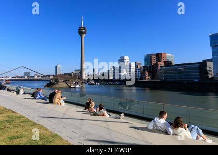 Düsseldorf, NRW, 2021. Am Sonntagnachmittag genießen die Menschen bei schönem, warmen Sonnenschein mit Temperaturen bis zu 18 Grad im beliebten Medienhafen, einem umbauten Gebiet am Rhein, in dem Medienunternehmen, Büros, Unterhaltung, Restaurants und Freizeiteinrichtungen in Düsseldorf, der Hauptstadt des bevölkerungsreichsten Bundeslandes Nordrhein-Westfalen, angesiedelt sind. Kredit: Imageplotter/Alamy Live Nachrichten Stockfoto