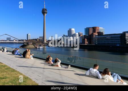 Düsseldorf, NRW, 2021. Am Sonntagnachmittag genießen die Menschen bei schönem, warmen Sonnenschein mit Temperaturen bis zu 18 Grad im beliebten Medienhafen, einem umbauten Gebiet am Rhein, in dem Medienunternehmen, Büros, Unterhaltung, Restaurants und Freizeiteinrichtungen in Düsseldorf, der Hauptstadt des bevölkerungsreichsten Bundeslandes Nordrhein-Westfalen, angesiedelt sind. Kredit: Imageplotter/Alamy Live Nachrichten Stockfoto