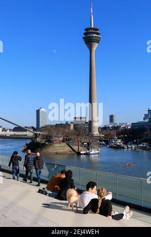 Düsseldorf, NRW, 2021. Am Sonntagnachmittag genießen die Menschen bei schönem, warmen Sonnenschein mit Temperaturen bis zu 18 Grad im beliebten Medienhafen, einem umbauten Gebiet am Rhein, in dem Medienunternehmen, Büros, Unterhaltung, Restaurants und Freizeiteinrichtungen in Düsseldorf, der Hauptstadt des bevölkerungsreichsten Bundeslandes Nordrhein-Westfalen, angesiedelt sind. Kredit: Imageplotter/Alamy Live Nachrichten Stockfoto