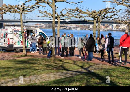 Düsseldorf, NRW, 2021. Vor einem Eiswagen hat sich eine lange Schlange gebildet. Am Sonntagnachmittag genießen die Menschen bei schönem, warmen Sonnenschein mit Temperaturen bis zu 18 Grad im beliebten Medienhafen, einem umbauten Gebiet am Rhein, in dem Medienunternehmen, Büros, Unterhaltung, Restaurants und Freizeiteinrichtungen in Düsseldorf, der Hauptstadt des bevölkerungsreichsten Bundeslandes Nordrhein-Westfalen, angesiedelt sind. Kredit: Imageplotter/Alamy Live Nachrichten Stockfoto