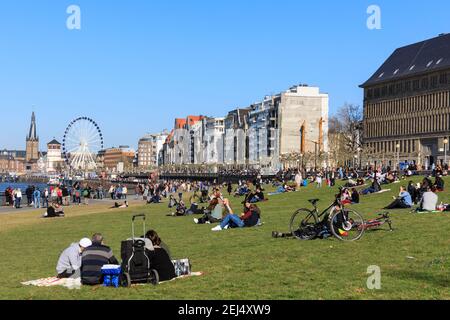 Düsseldorf, NRW, 2021. Die Menschen genießen ihren Sonntagnachmittag bei schönem warmen Sonnenschein bei Temperaturen bis zu 18 Grad, bummeln am Rhein entlang und entspannen auf der Wiese in Düsseldorf, der Hauptstadt des bevölkerungsreichsten Bundeslandes Nordrhein-Westfalen. Kredit: Imageplotter/Alamy Live Nachrichten Stockfoto