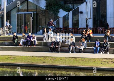 Düsseldorf, NRW, 2021. Den Sonntagnachmittag genießen die Menschen bei schönem, warmen Sonnenschein bei Temperaturen bis zu 18 Grad am Kö-Bogen in der Nähe der berühmten Einkaufsmeile Königsallee in Düsseldorf, der Hauptstadt des bevölkerungsreichsten Bundeslandes Nordrhein-Westfalen. Kredit: Imageplotter/Alamy Live Nachrichten Stockfoto