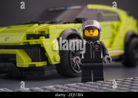 Tambov, Russische Föderation - 14. Februar 2021 Lego Lamborghini Fahrer Minifigur steht in der Nähe ihres Lamborghini Urus ST-X Lego Speed Champions Auto. Stockfoto