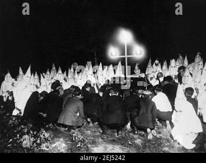 Ku Klux Klan. Umhüllte Mitglieder des Klan im Hintergrund mit neuen Kandidaten kniend vor ihnen, Washington DC, c. 1920-1930 Stockfoto