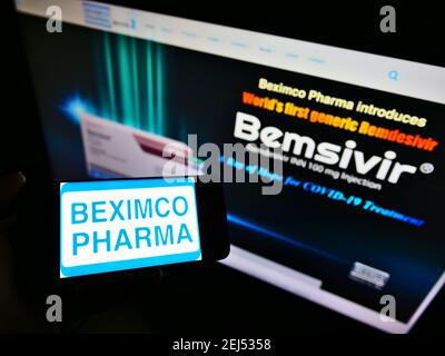 Person, die das Smartphone mit dem Logo des bangladeschischen Unternehmens Beximco Pharmaceuticals Ltd auf dem Bildschirm vor der Website hält. Konzentrieren Sie sich auf die Telefonanzeige. Stockfoto