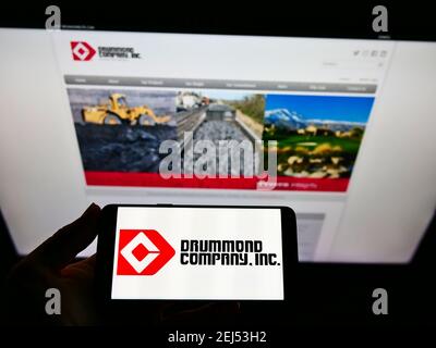 Person hält Smartphone mit Logo des amerikanischen Bergbauunternehmens Drummond Company Inc. Auf dem Bildschirm vor der Website. Konzentrieren Sie sich auf die Telefonanzeige. Stockfoto
