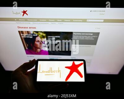 High-Angle-Ansicht der Person hält Handy mit Logo des dänischen Pharmaunternehmens H. Lundbeck auf dem Bildschirm mit Webseite. Konzentrieren Sie sich auf die Telefonanzeige. Stockfoto