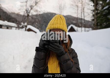 Ein Fotograf macht ein Bild, während er in einem Berg steht Landschaft in der Kälte mit Schnee Stockfoto
