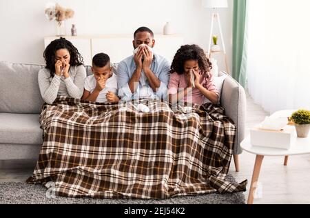 Sick schwarze Familie bläst Nasen mit Servietten zusammen Stockfoto