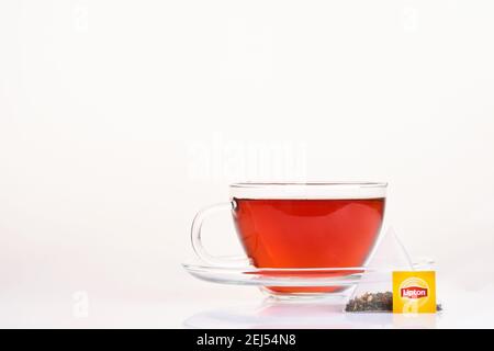 MOGILEV, WEISSRUSSLAND - DEZEMBER 15 2020: Lipton gelb Label Teebeutel in brauner Glas Tasse auf isoliert auf weißem Hintergrund. Lipton ist eine britische Marke von te Stockfoto