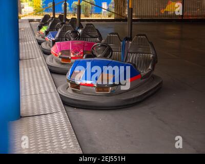 Bunte elektrische altmodische Stoßfänger Autos für zwei stehend in einer Reihe in einer Stadt Vergnügungspark. Traditionelle Familienunterhaltung und aktive Erholung. Stockfoto