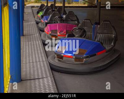 Bunte elektrische altmodische Stoßfänger Autos für zwei stehend in einer Reihe in einer Stadt Vergnügungspark. Traditionelle Familienunterhaltung und aktive Zeit. Stockfoto