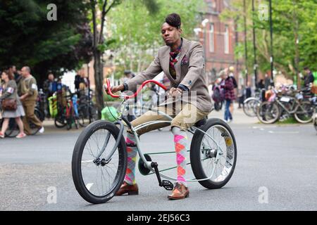 Britischer afrikanisch-karibischer Mann in Tweed sitzend auf Lowrider Custom Fahrrad in London, Großbritannien Stockfoto
