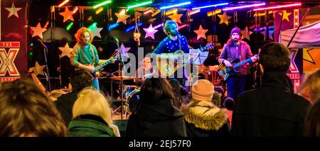 Eine lokale Rockband spielt einen öffentlichen Weihnachtsgig im Navigator Square, Archway, London, Großbritannien Stockfoto