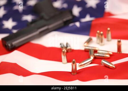 Viele gelbe 9mm Kugeln und Pistole auf US-Flagge. Konzept des Waffenhandels auf US-Territorium oder US-Schießstand Stockfoto