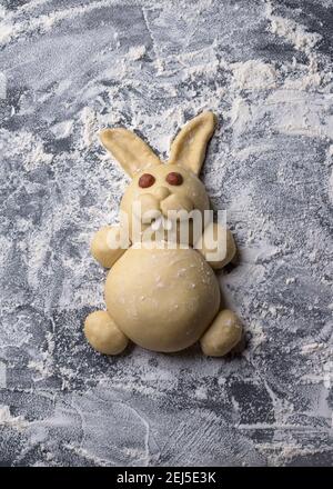 Rohe Osterhasen von köstlichen süßen Teig auf einem Tisch mit Mehl bestreut, Draufsicht Stockfoto