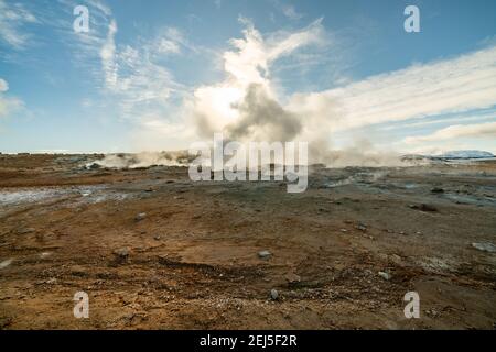 Namafjall Hverir Geothermiegebiet in Island. Atemberaubende Landschaft von Schwefel Tal mit rauchenden Fumarolen und blau bewölkten Himmel, Reise Hintergrund Stockfoto