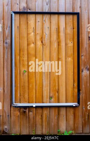 Leerer Werberahmen auf einem Holzzaun Stockfoto