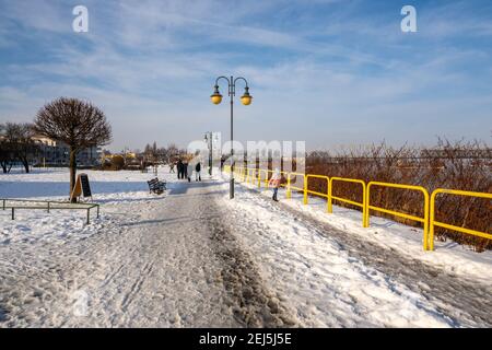 Tczew, Polen - 21. Februar 2021: Uferpromenade Weichsel in Tczew. Die historische Brücke im Hintergrund. Polen. Stockfoto