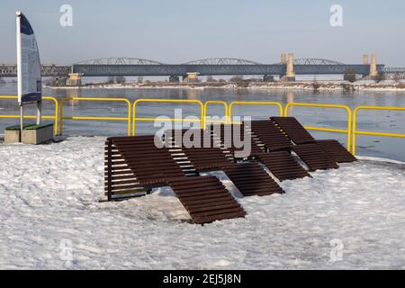 Tczew, Polen - 21. Februar 2021: Entspannungszone an der Uferpromenade in Tczew. Die historische Brücke im Hintergrund Stockfoto