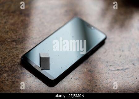 Smartphone-Bildschirm mit gehärtetem Glas zum Schutz vor Kratzern. Wassertropfen auf dem Bildschirm. Reinigen des Touchscreens. Stockfoto